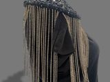 an image of a mannequin wearing a black dress with gold chains on it