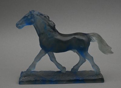 un cheval en verre posé sur un socle