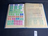 an open book with stamps on it sitting on a table