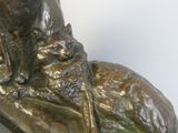 a bronze statue of a man with a cat on his lap