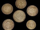 a group of five silver coins with different designs on them