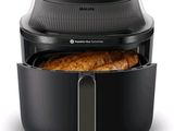 un gros plan sur une friteuse à air chaud noire contenant une miche de pain