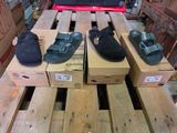 Plusieurs paires de chaussures sont posées sur des cartons, sur une palette.