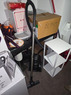 un aspirateur posé dans une pièce, à côté d'une table