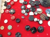 many different types of buttons on a red table