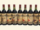 six bottles of red wine lined up in a row