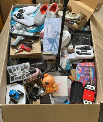 une boîte en carton remplie d'objets hétéroclites sur le sol