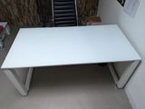 a white desk with a black chair in the corner of the room