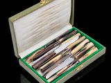 a box with a set of knives in it on a black surface