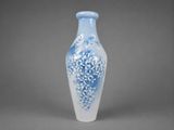 a blue and white vase sitting on a gray surface
