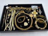 un plateau sur lequel sont disposés de nombreux bijoux en or