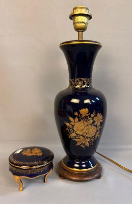 a blue vase with a gold decoration next to a small box