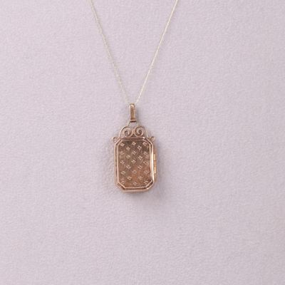 a small gold locke necklace with a chain that is attached to it