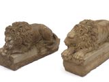 une paire de lions sculptés dans la pierre, posés sur des socles, sur fond blanc