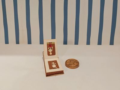 a small book sitting on a table next to a penny