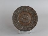 une image représentant une plaque métallique ornée d'un motif