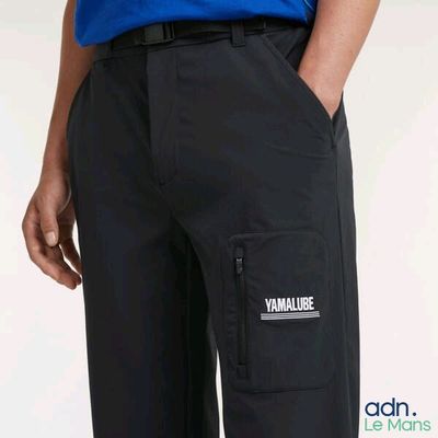 a close up of a person wearing a blue shirt and black pants