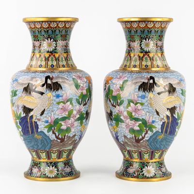 pair of oriental vases decorated with cranes and flowers on a white background