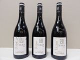 trois bouteilles de vin posées sur une table, l'une à côté de l'autre