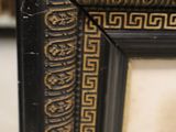 a close up of a black and gold frame with a pattern on it