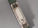 a green and white train car on a gray surface