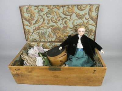 une poupée posée dans une boîte en bois sur une table