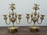 pair of antique brass candelabs on a wooden table