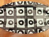 a black and white oval platter on a wooden floor