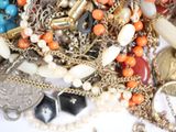 a pile of assorted jewelry on a white surface