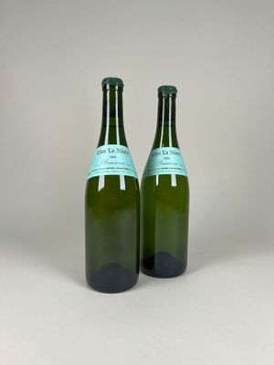 two bottles of wine sitting on top of a table next to each other