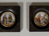 une paire de miniatures encadrées représentant des personnages et des animaux sur un mur blanc