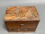 a small wooden box with a painting on it