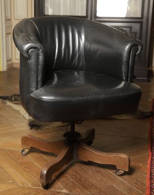 a black leather office chair sitting on a wooden floor