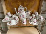 a glass shelf with a tea set and cups on it