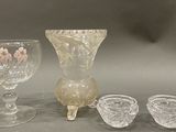 three glasses and a vase sitting on a table