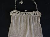 an old purse with a chain attached to it on a black background