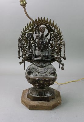 une image représentant une statue en bronze d'une personne assise sur un lotus