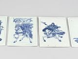four blue and white tile paintings of people on a white surface
