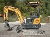 a picture of a small excavator parked in a gravel lot