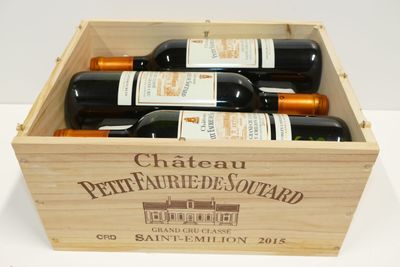 bouteilles de vin dans un coffret en bois sur une surface blanche