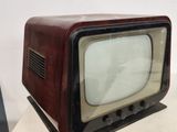 an old television sitting on top of a white table