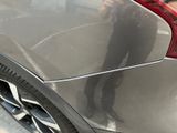 a man taking a picture of a car with his cell phone