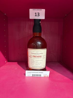 une bouteille de whisky dans une boîte rose avec une étiquette de prix