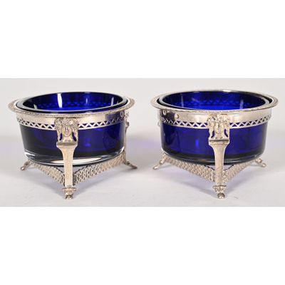 a pair of blue glass bowls with silver handles