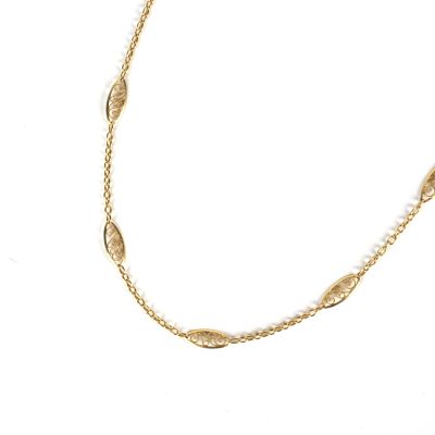 a close up of a gold necklace on a white background