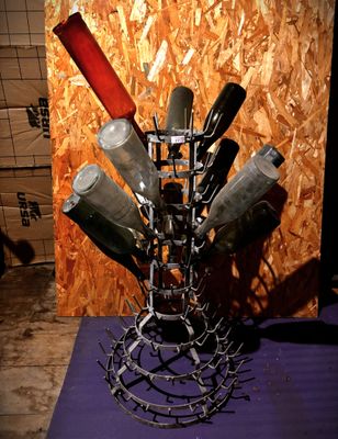 un porte-bouteilles fabriqué à partir de bouteilles de vin, posé sur un tapis violet