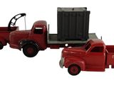 un camion jouet rouge avec une remorque attachée à l'arrière