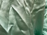 a close up of a bed with a green comforter