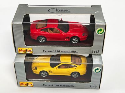 deux petites voitures rouges et jaunes dans une boîte