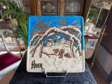 a tile with a picture of a man and a woman in a manger